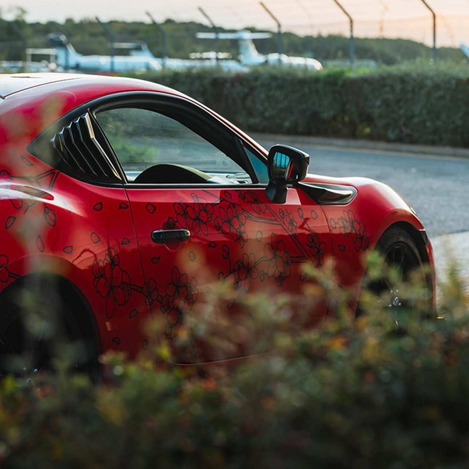 red sports car with blossom automotive sakura livery