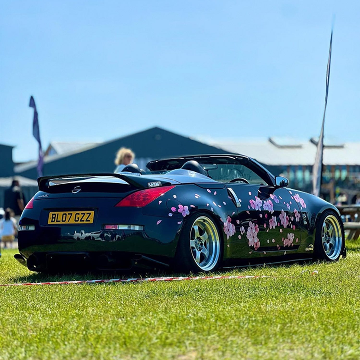 Black convertible car with floral Blossom design on a grassy field