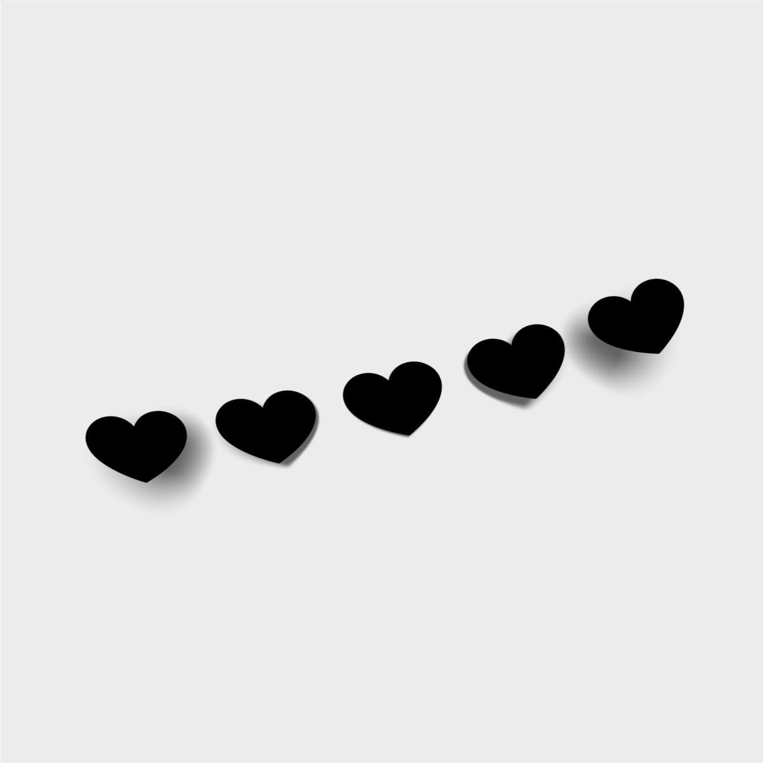 The Blossom Automotive Small Hearts - Die Cut Sticker features five black heart shapes arranged diagonally on a light gray background, each with a soft shadow to the lower left.