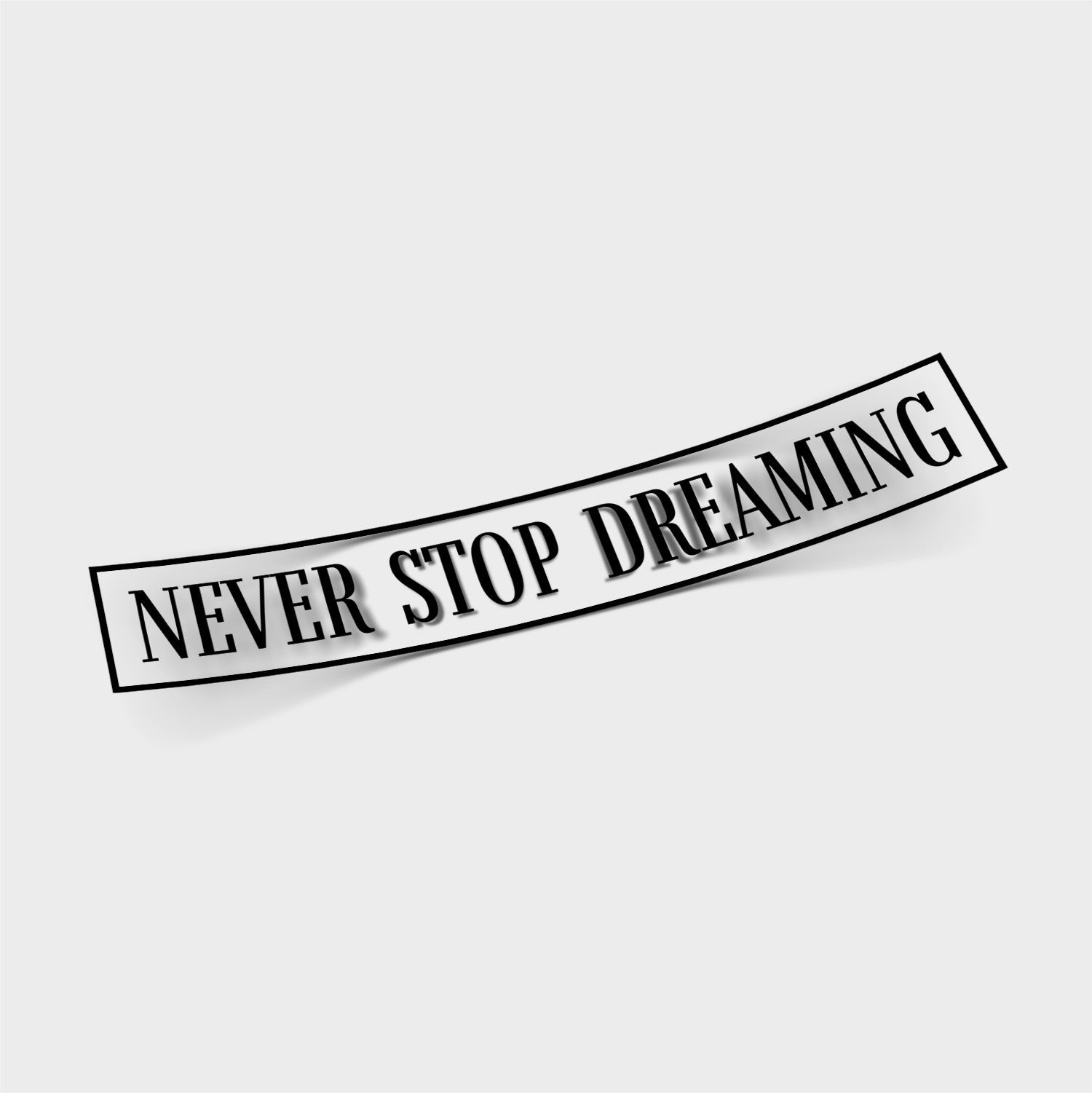 The Blossom Automotive Never Stop Dreaming - Die Cut Sticker features bold black text on a white rectangular design, slightly curved, with the inspiring message "NEVER STOP DREAMING" on a plain white background.