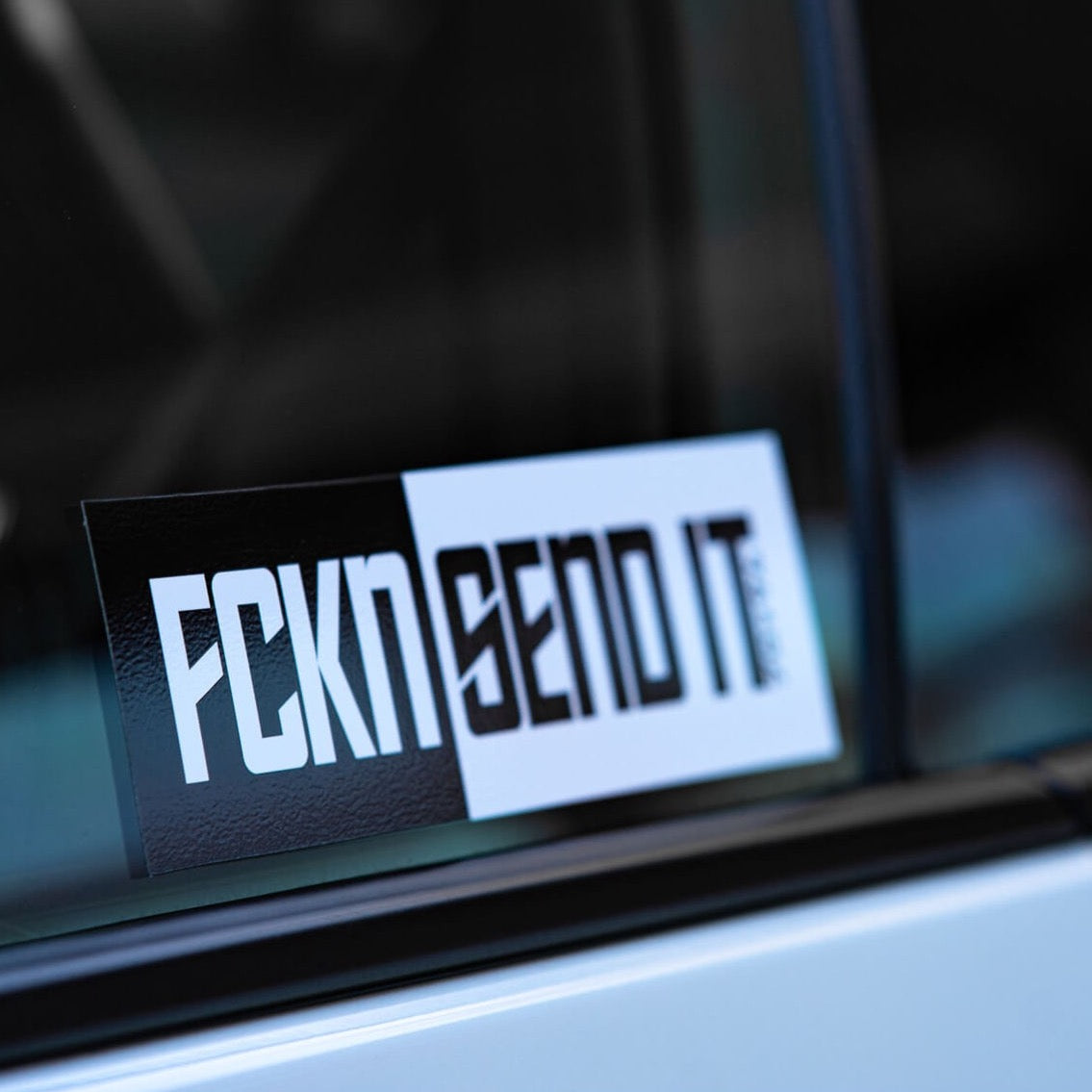 The Blossom Automotive FCKN Send It - Slap Sticker features bold, stylized black and white lettering, perfect for displaying on your car window.