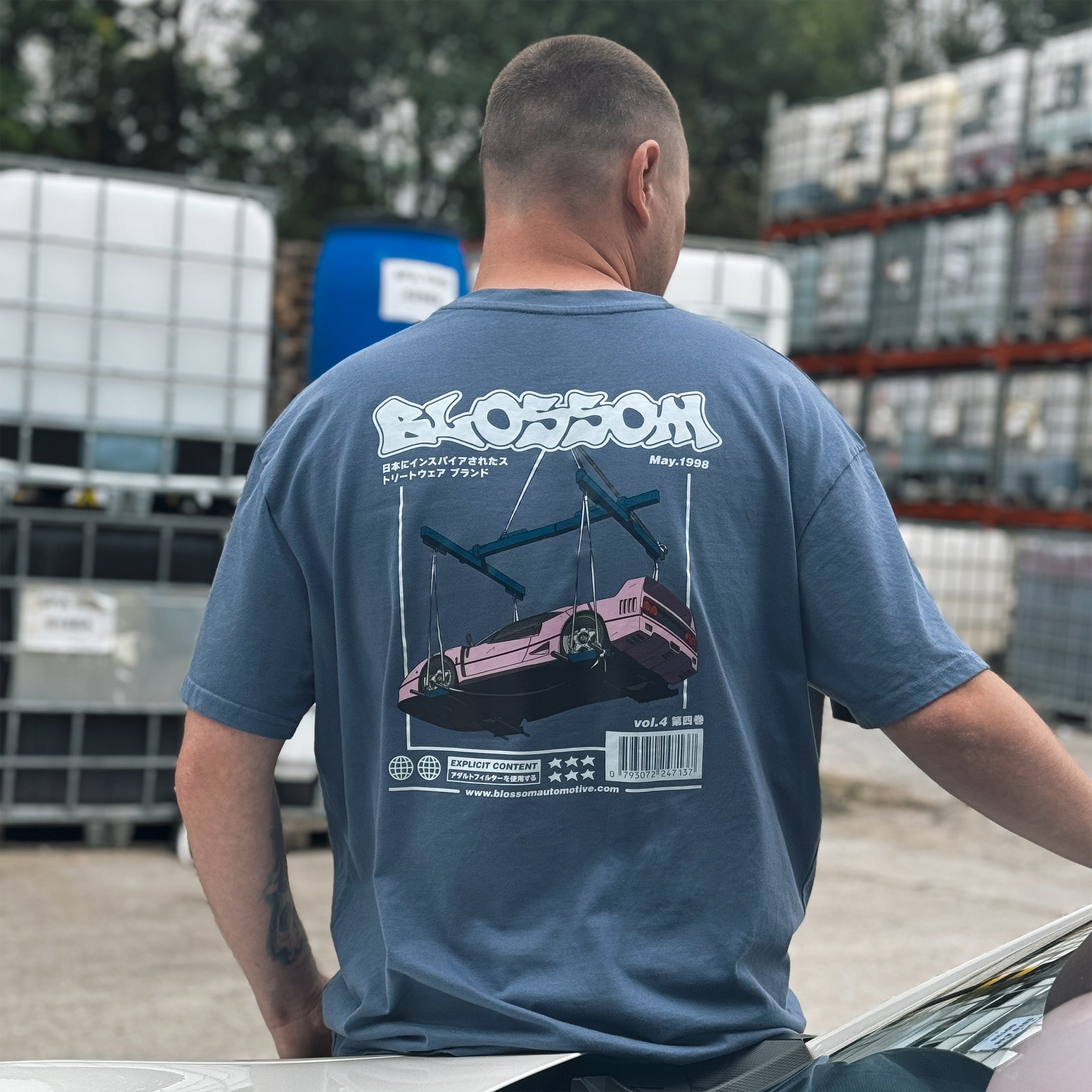 person wearing the blue bubblegum collection t-shirt while leaning on a car