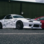 White car with cherry blossom floral design livery parked on a road
