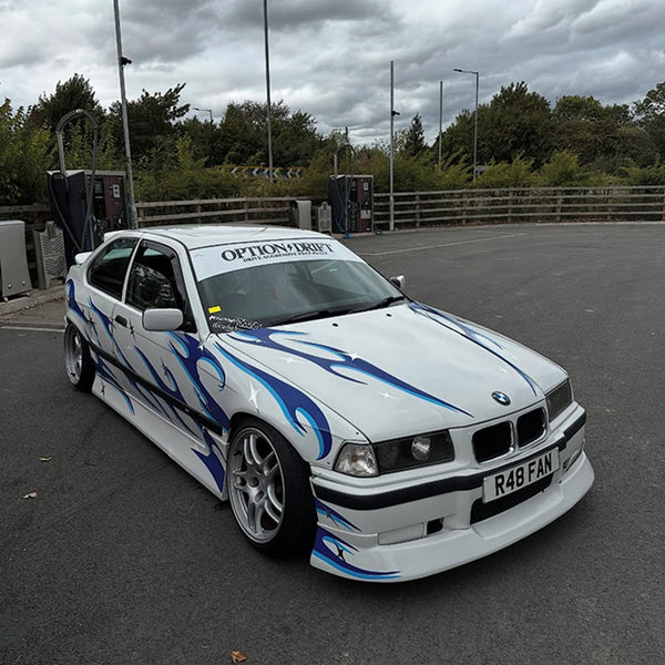 White BMW car with blue livery graphics on a track