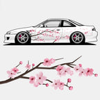 The Blossom Automotive DIY Pink Cherry Blossoms - Printed Livery features a white sports car with pink cherry blossom graphics, displayed above an illustrated branch adorned with pink flowers and buds.