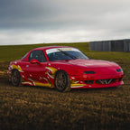 Red sports car with Blossom Automotive Zoku flame design on a grassy field