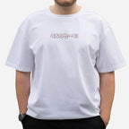 A person models the Blossom Automotive "The Milkshake Collection" Oversized T-Shirt in white, featuring light pink Japanese text on the chest. The face is not visible, and the background is plain white.