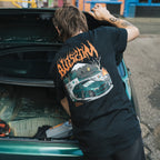 Model standing next to IS200 while wearing Blossom Skate Collection black tee, featuring Lexus IS200 graphic, oversized fit, inspired by skate and drift culture