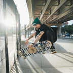 Model skateboarding while wearing Blossom Skate Collection black tee, featuring Lexus IS200 graphic, oversized fit, inspired by skate and drift culture