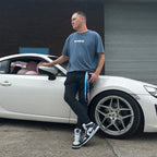 A person standing by a car wearing a vintage blue Bubblegum Collection T-shirt