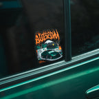 Blossom Automotive's The Skate Collection - Slap Sticker features a drifting car, graffiti wall, smoke, palm trees, and Blossom in fiery orange on a green car window.
