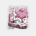 A pink sports car and strawberry milk sit under cherry blossoms in this vibrant, anime-style scene. Japanese text and the Blossom Automotive logo enhance The Milkshake Collection - Slap Sticker's bold aesthetic.