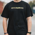 a front shot of a person wearing a black mx5 tee