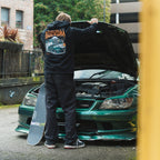 a person looking under the hood of a green is200 wearing the black skate collection hoodie