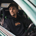 a person sat inside a drift car wearing the black skate collection hoodie