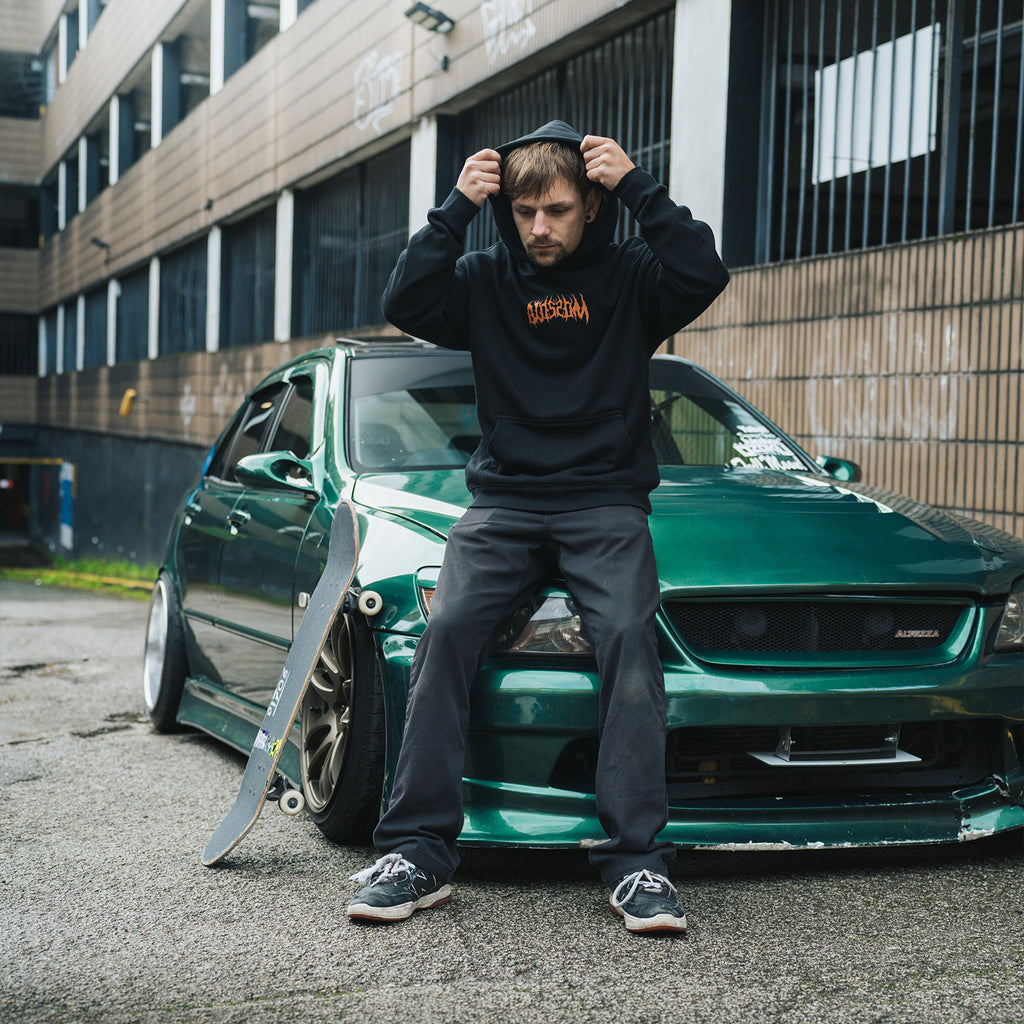 a person sat on a green Lexus is200 wearing the black skate collection hoodie