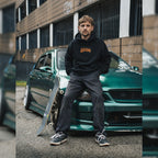 a person sat on a green is200 wearing a black skate collection hoodie