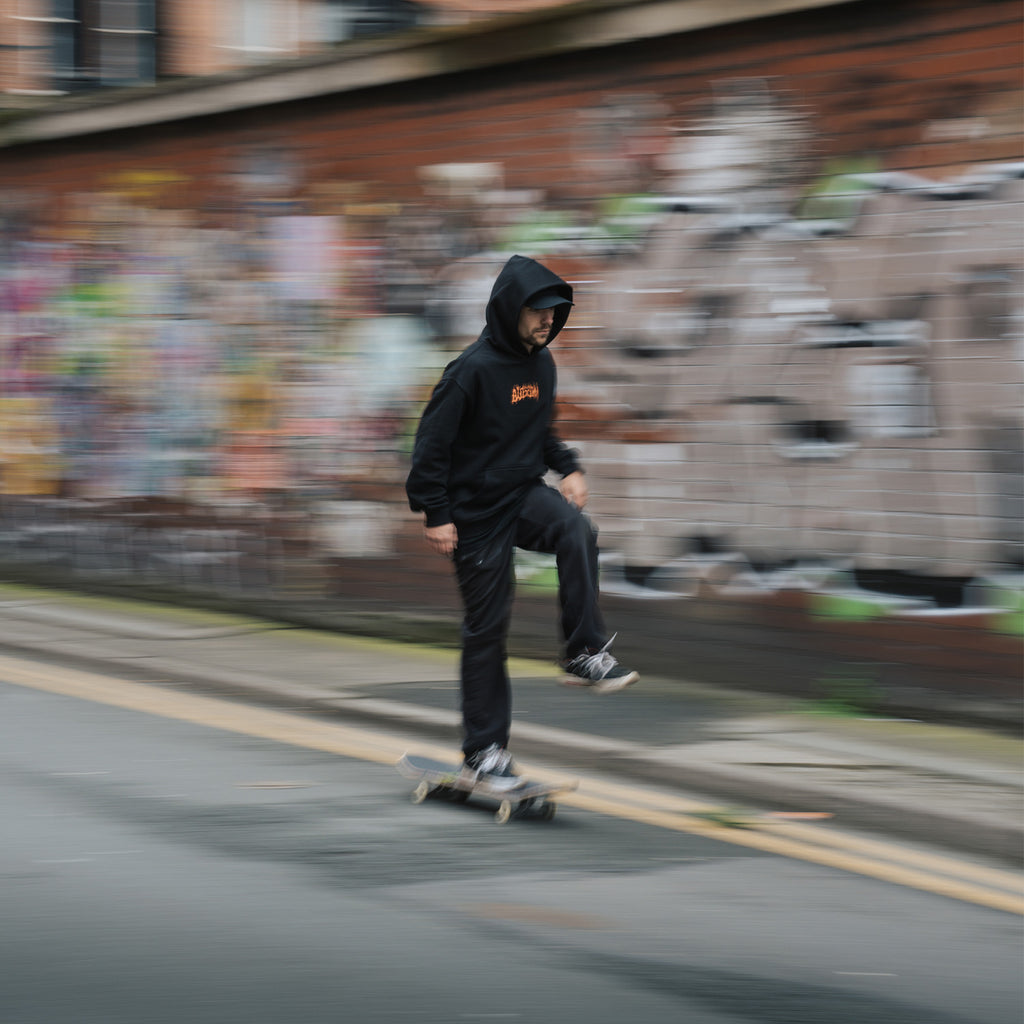 a person skateboarding while wearing the black skate collection hoodie