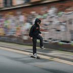 a person skateboarding while wearing the black skate collection hoodie