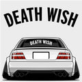 Illustration of a white sports car with wide tires, spoiler, and blank plate. "Death Wish - XL Rear Window Die-Cut Sticker" by Blossom Automotive is displayed in bold above and on the rear windshield.