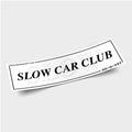 The Blossom Automotive Slow Car Club - Slap Sticker features bold black "SLOW CAR CLUB" lettering, a faint SLOW outline, Japanese text and a website in the corners, all on a white rectangular background.